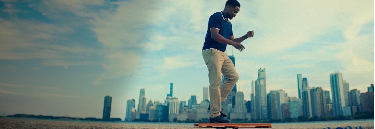 Dulé Hill walking with the Chicago skyline in the background