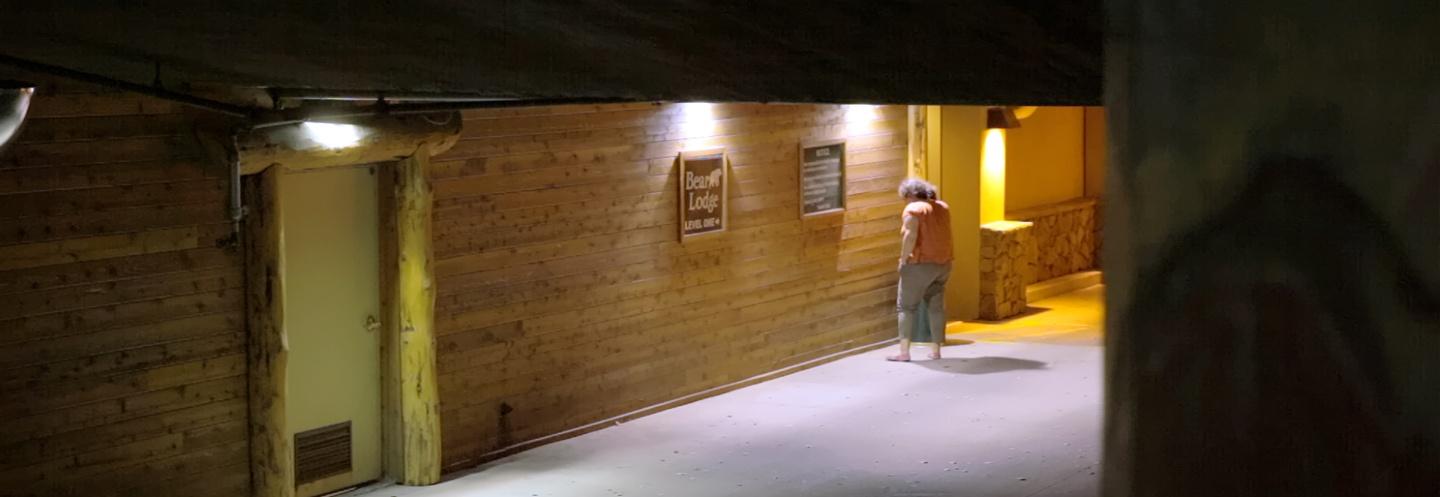 A barefoot woman standing outside of Bear Lodge
