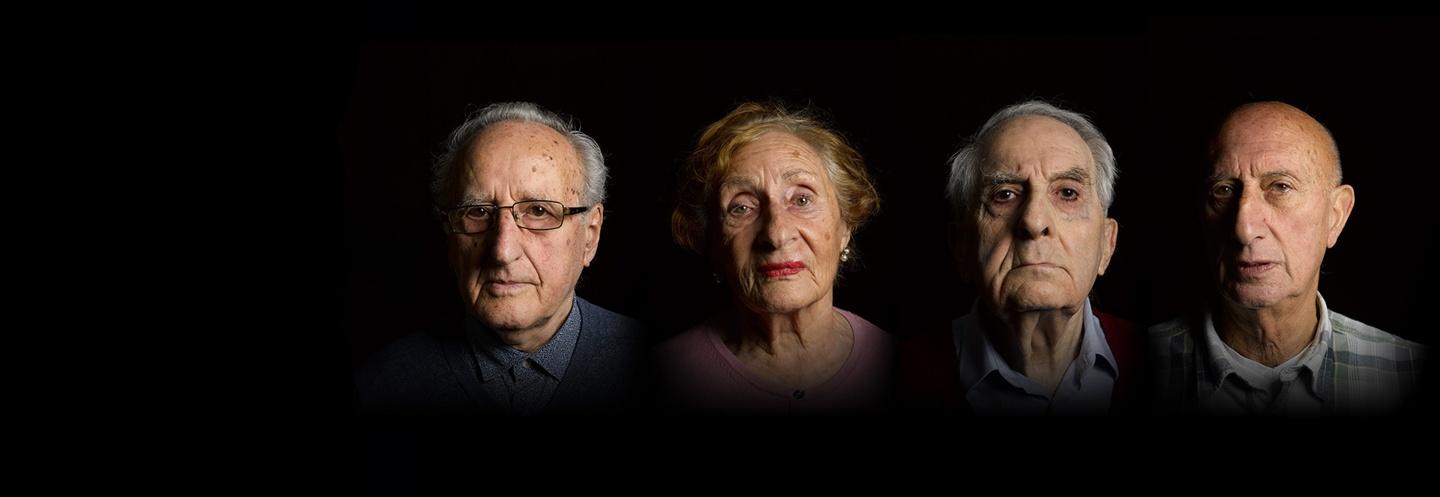 4 Holocaust survivors (3 men and a woman) looking at the camera