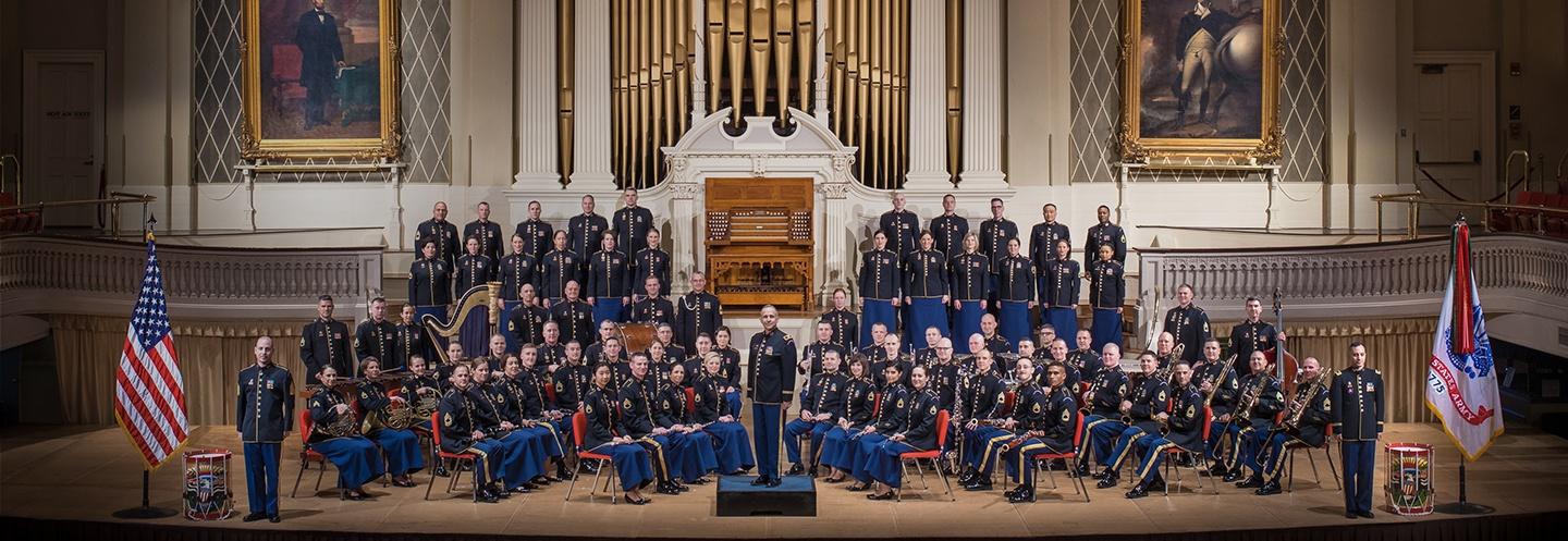 The Army Field Band assembled in their formal wear on a stage