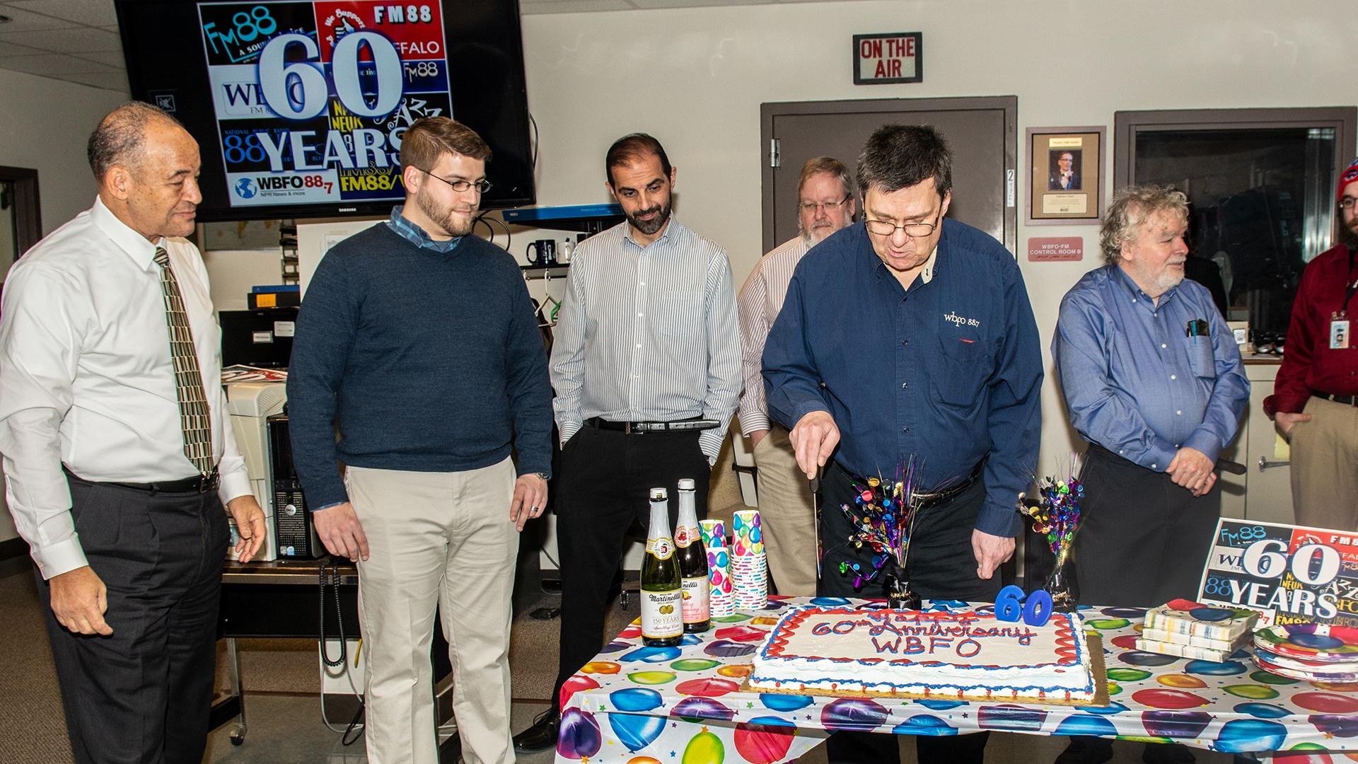 Mark Wozniak the longest current WBFO employee cut the cake to begin the celebration