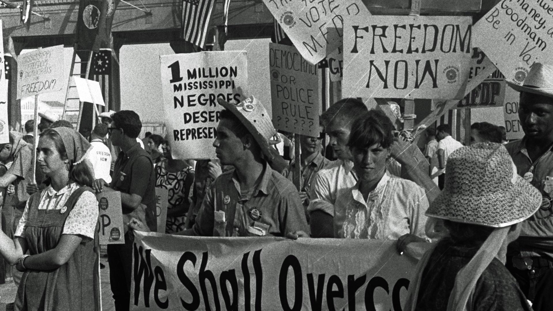 African American and white supporters of the Mississippi Freedom Democratic Party holding signs in front of the convention hall at the 1964 Democratic National Convention, Atlantic City, New Jersey.