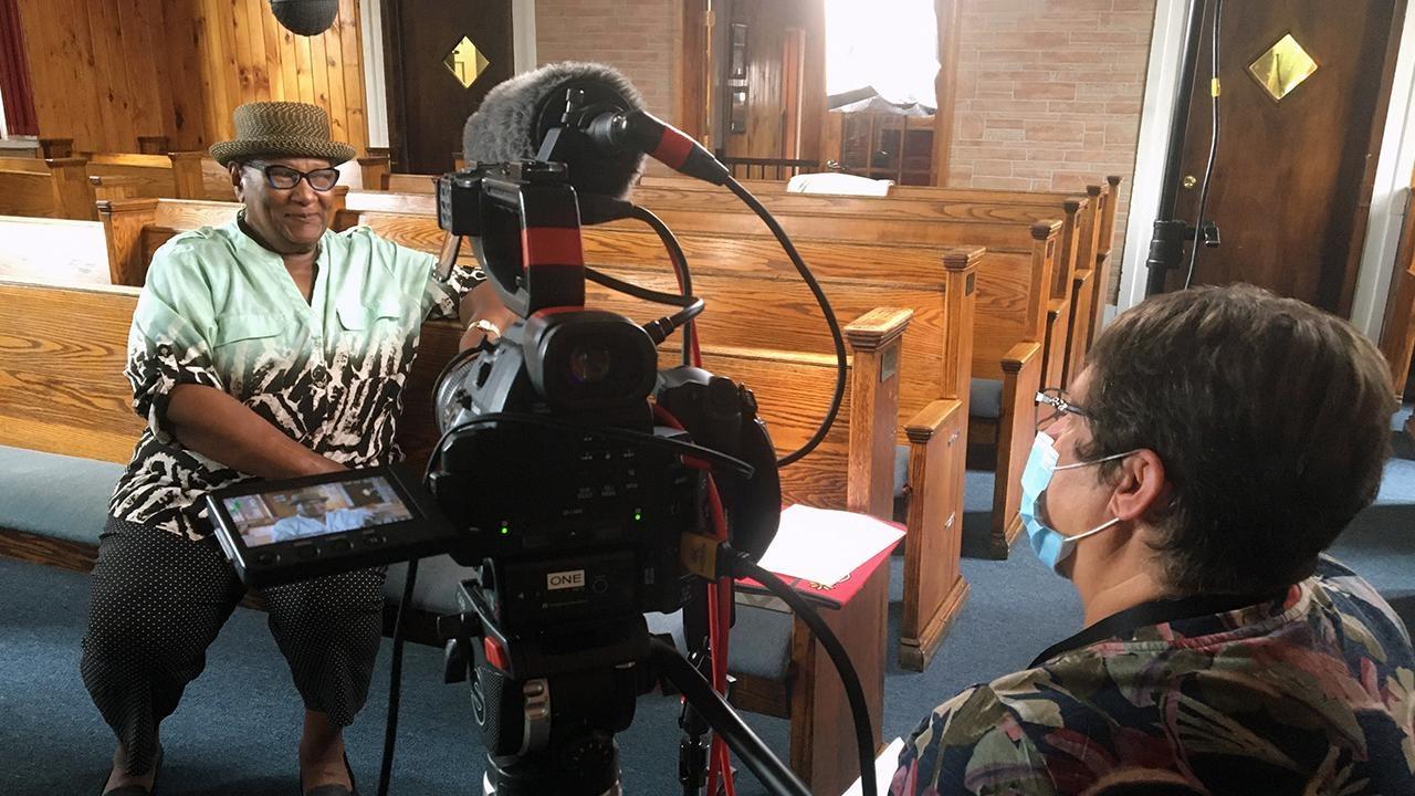 May Craig sits in front of a camera