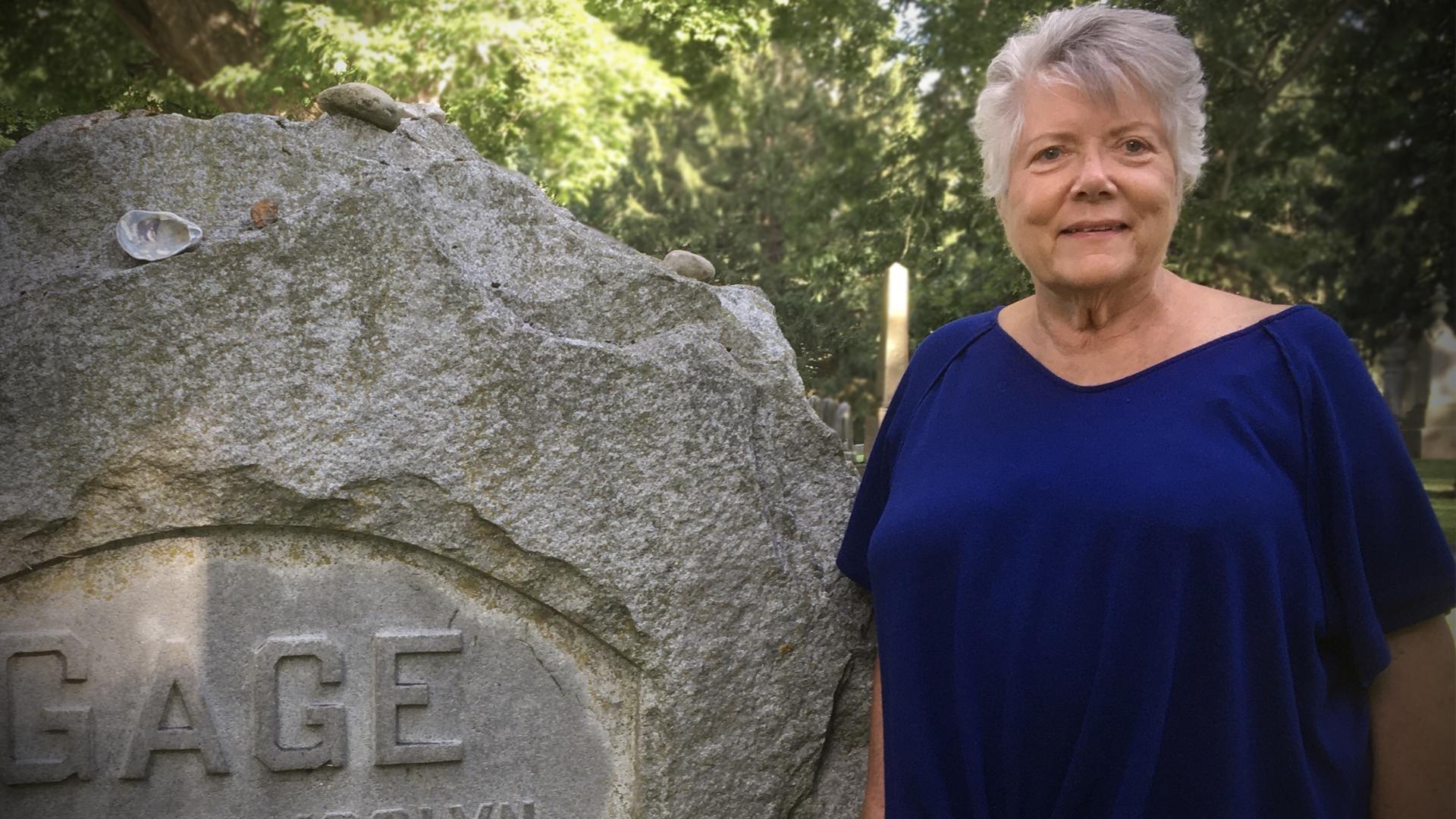 Sally Roesch Wagner stands in front of  Matilda Joslyn Gage's grave