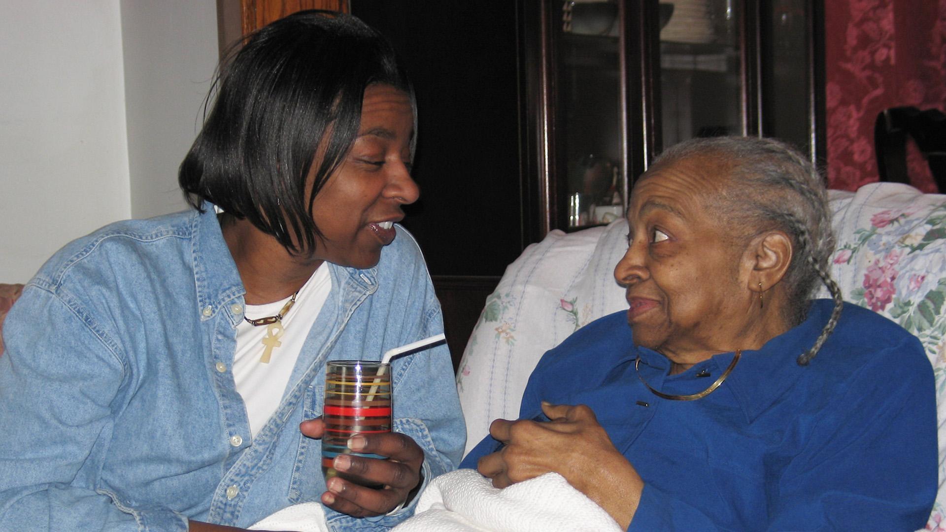 Caregiver checks in with her elderly loved one.