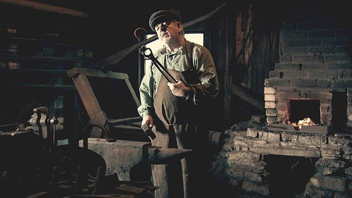 Still from the film: Actor making manacles.