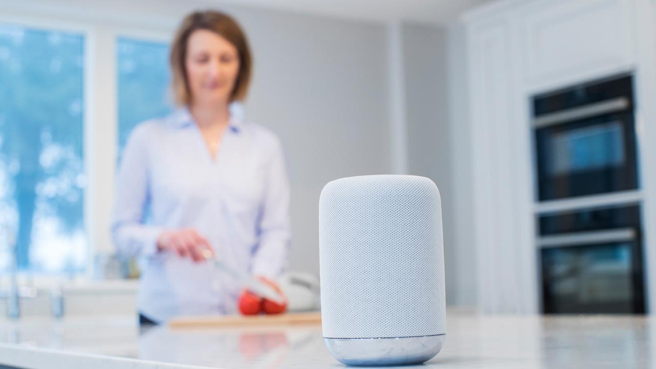 smart speaker in kitchen with woman chopping vegetables