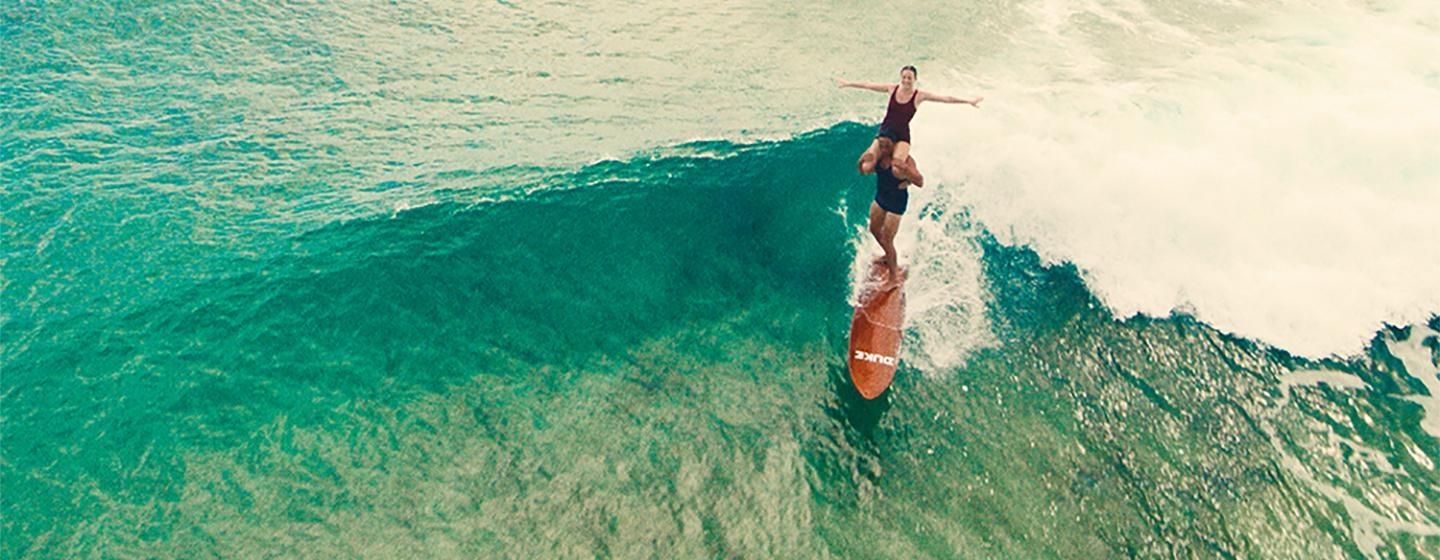 Waterman depicts the jaw-dropping tandem surfing ride with Isabel Letham, a young woman who would go on to become an accomplished surfer. 