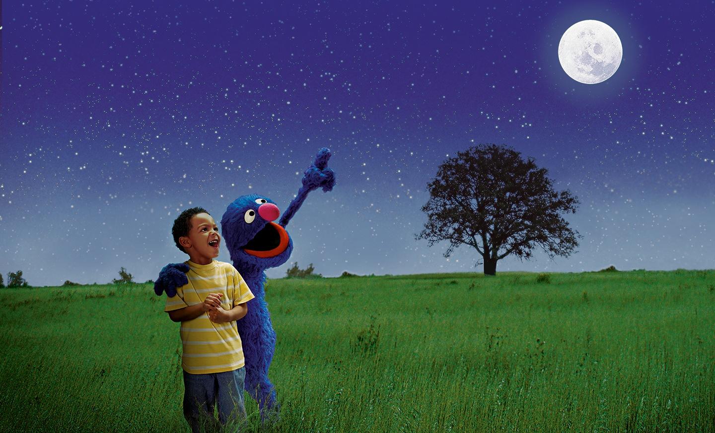 Grover with young boy looking at sky.