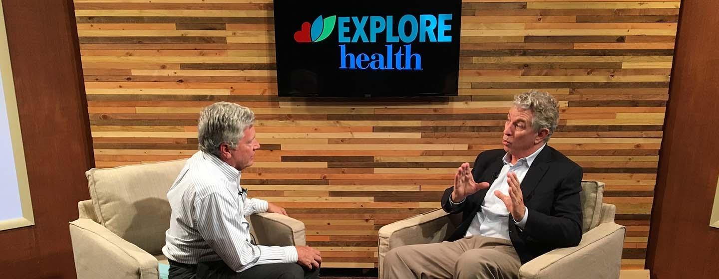 Explore Health host Ron Harr talks to guest, Dr. Bruce Perry on the set of Explore Health