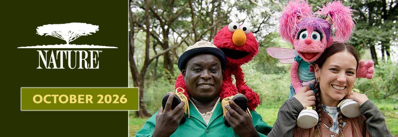 Nature October 2026 banner featuring Elmo and Abby Cadabby with two smiling people in a wooded setting.