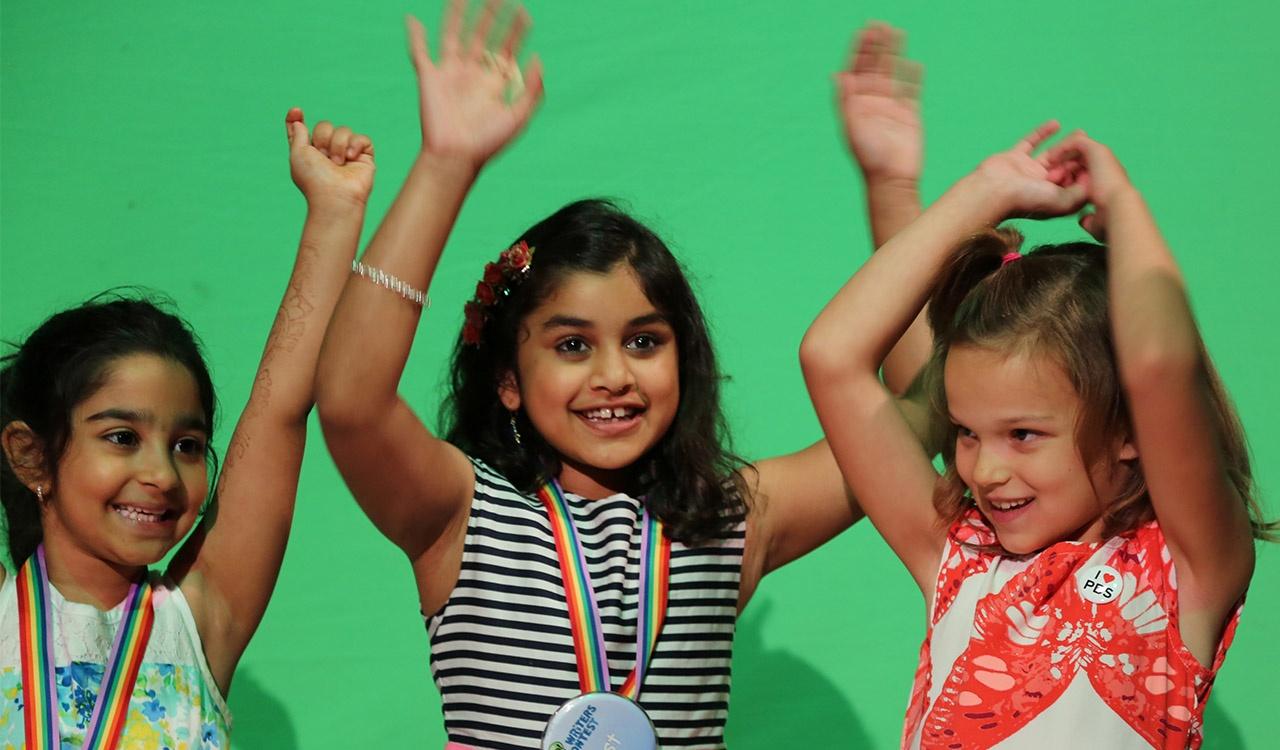 Three Writers Contest Winners laughing in front of green screen at 2017 Event