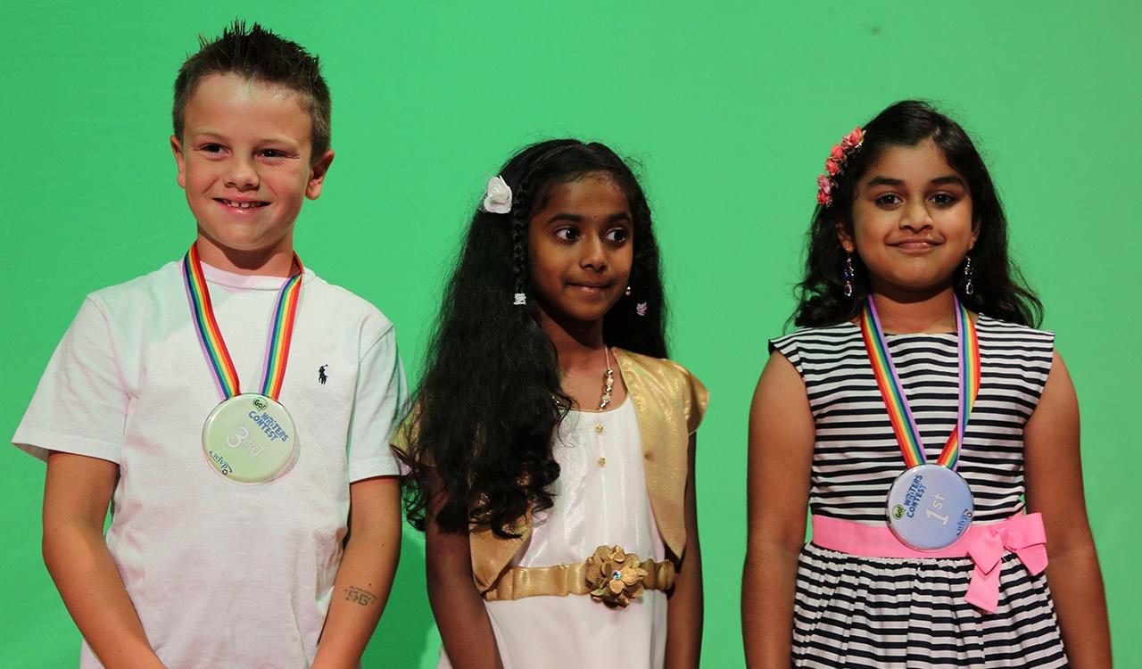 Three 2017 Writers Contest winners in front of green screen