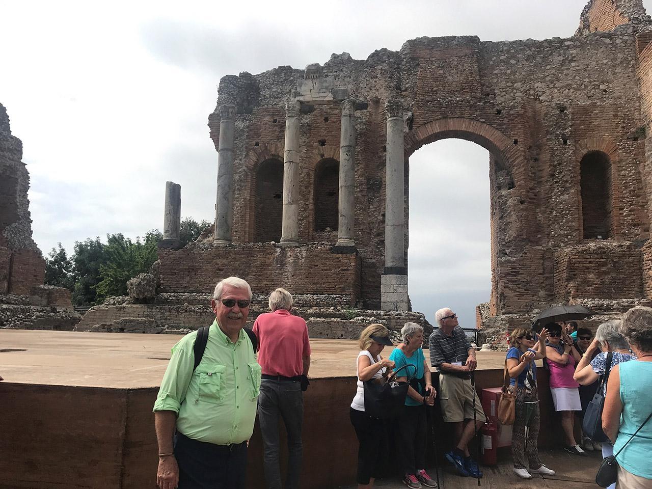 Travels and Chet Tomczyk standing in Greek theater