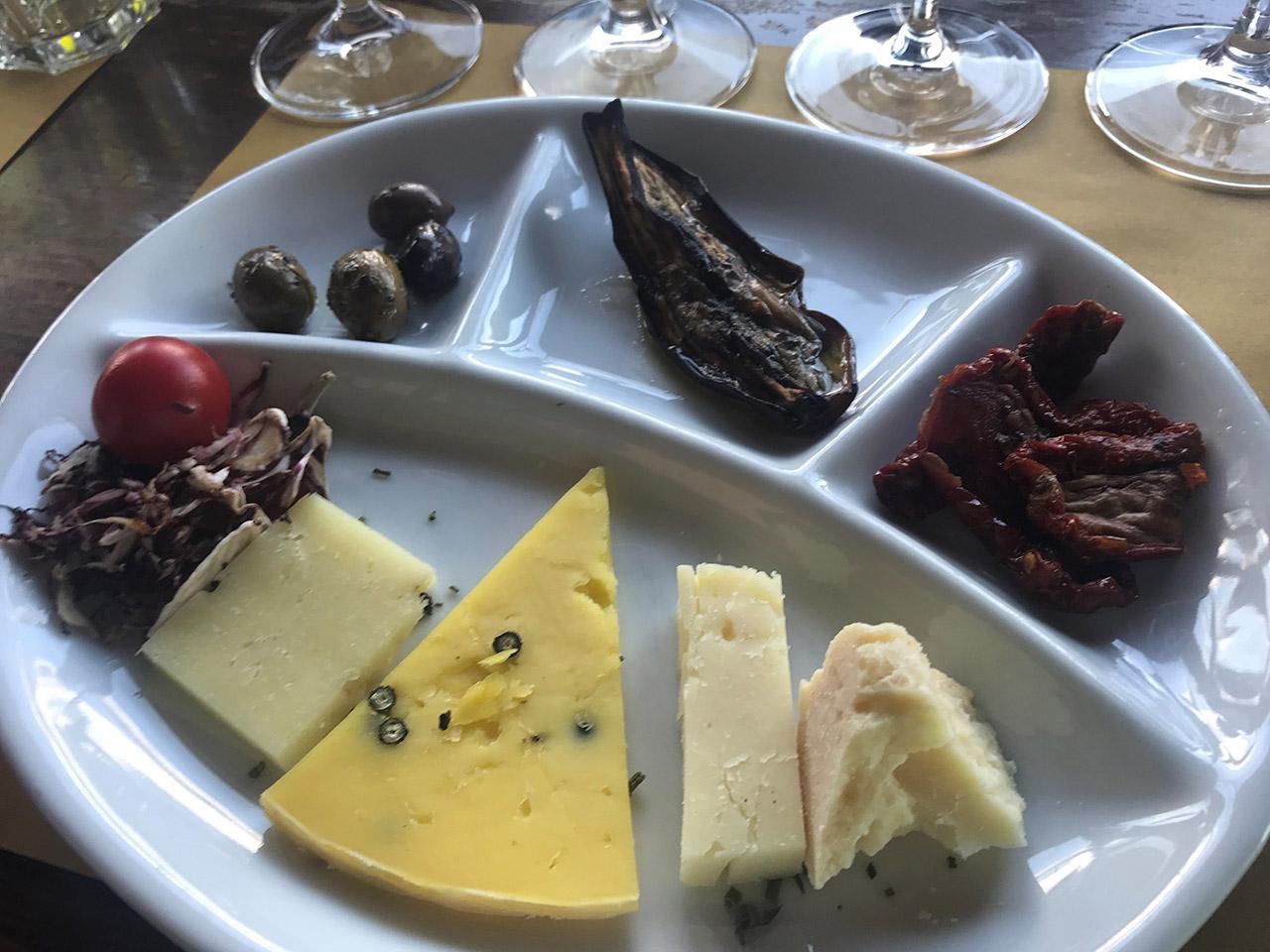 plate with various cheeses and other food.