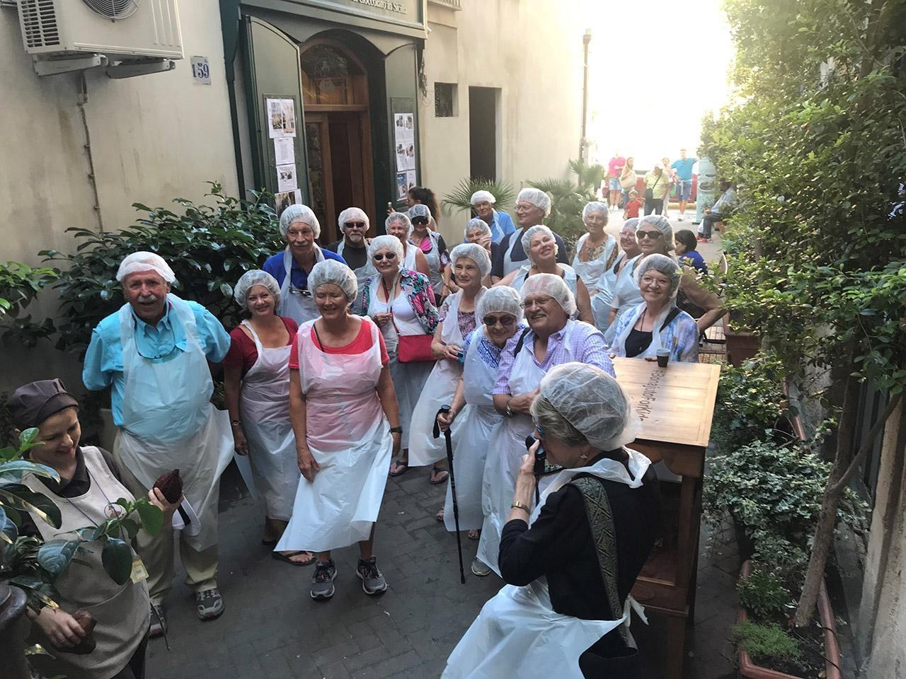 Travelers in group dress with white plastic aprons and hair caps