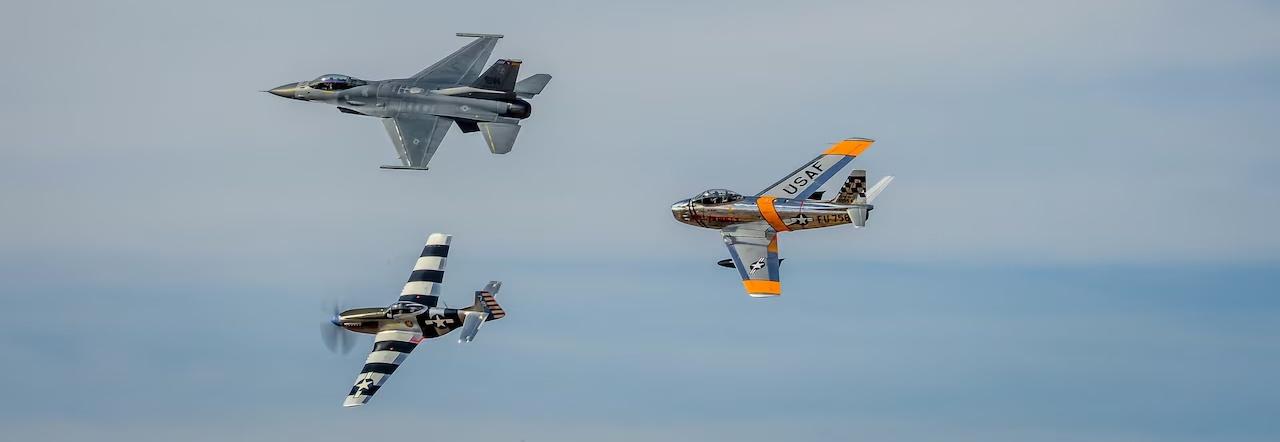 Three military jets fly in formation against a cloud-streaked sky