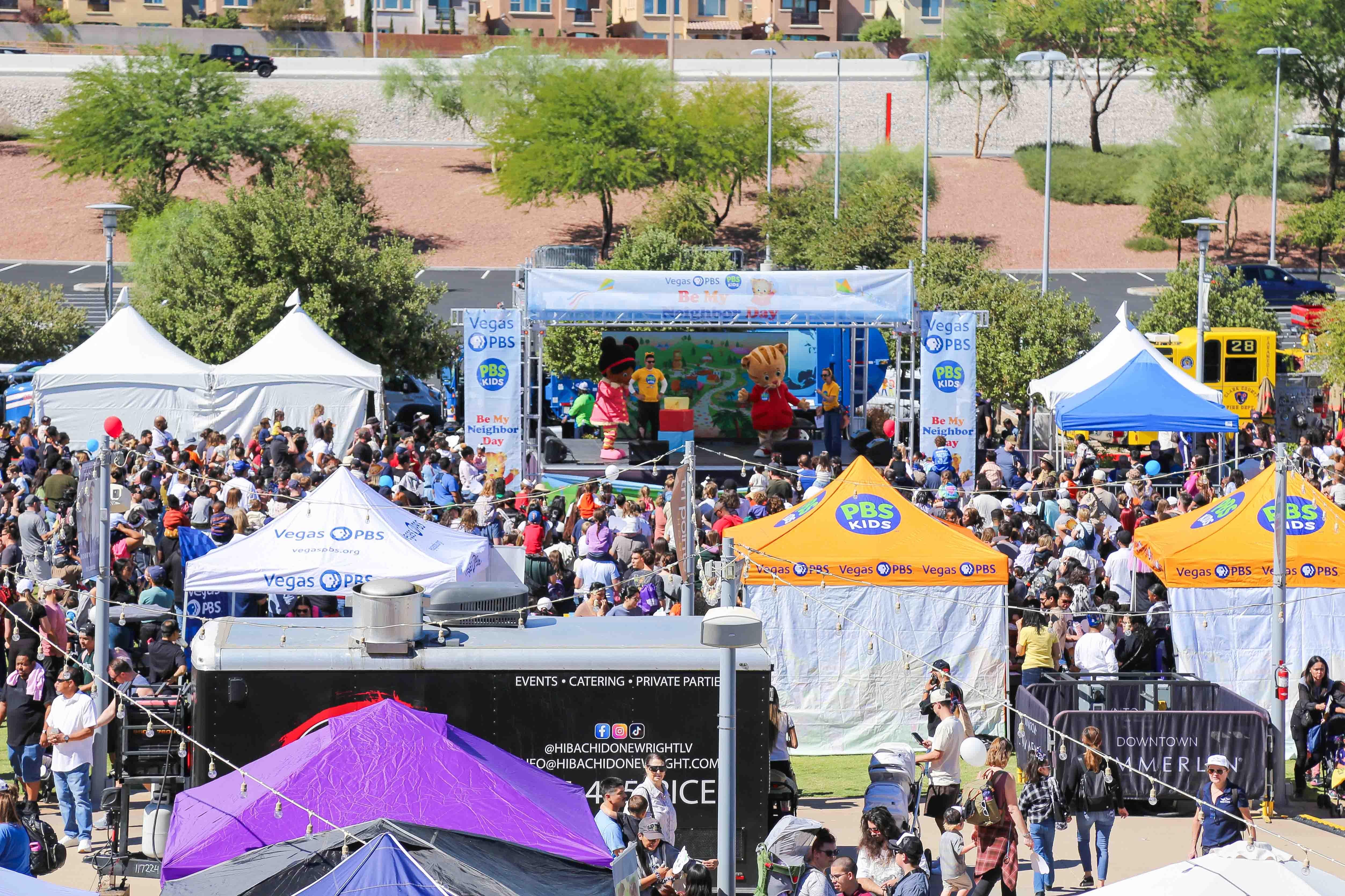 An outdoor festival with brightly colored tents and a stage