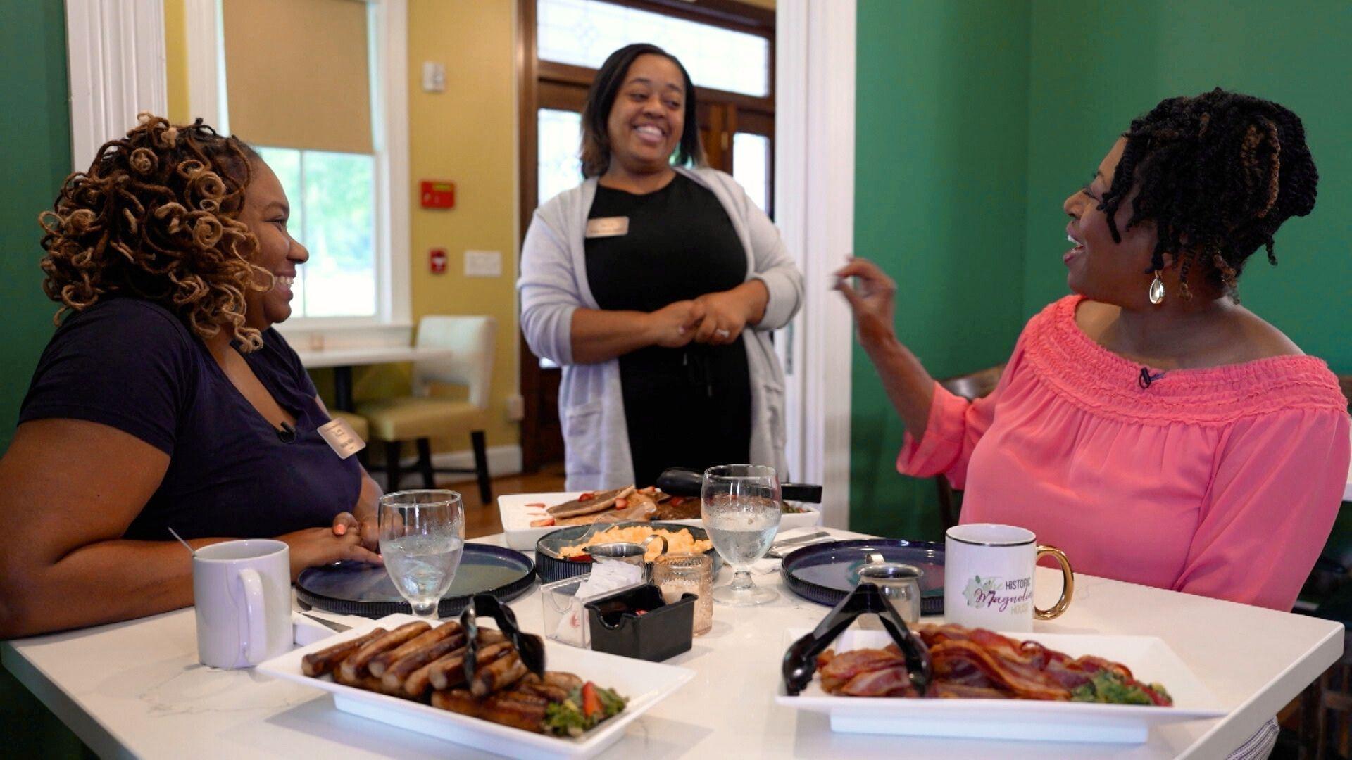 Host of NC Weekend, Deborah Holt Noel sits with two workers of the historic Magnolia House while enjoying a big breakfast.