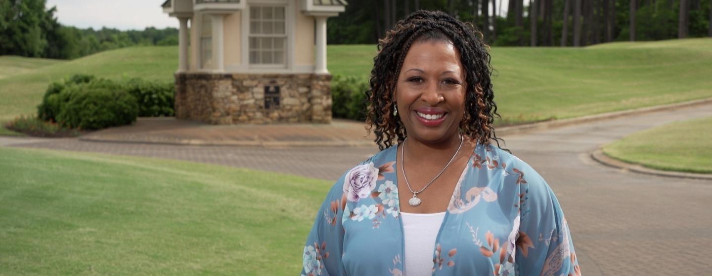 Host of NC Weekend, Deborah Holt Noel standing in front of a golf course.