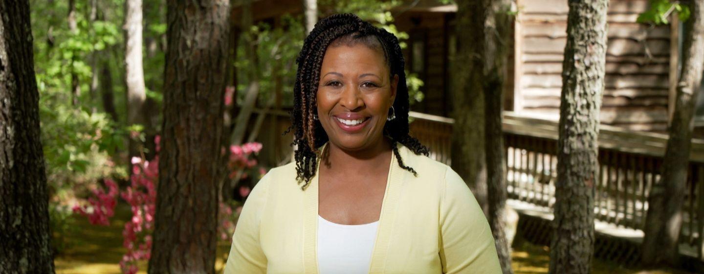 Deborah Holt Noel, host of NC Weekend in front of trees.