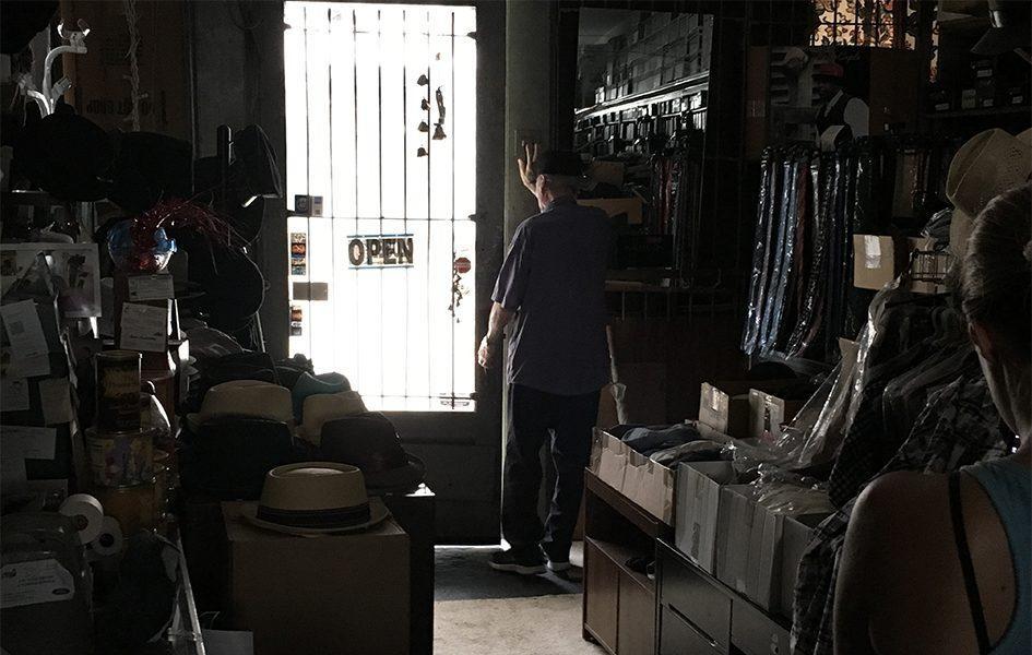 John Mitchell standing inside store by front door with open sign hanging on it