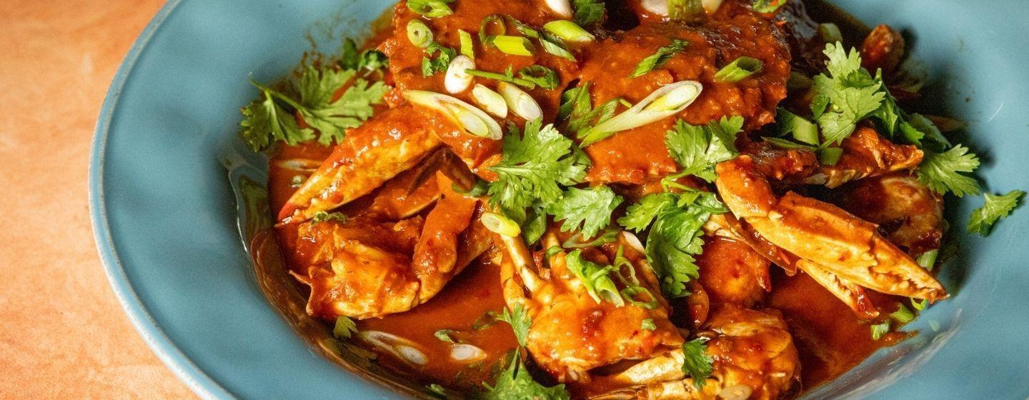 A teal ceramic bowl full of crab chili.