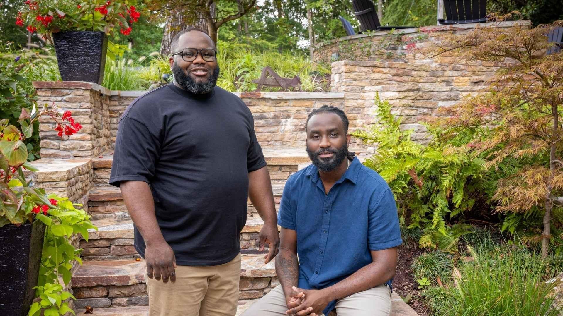 Oscar Johnson and Daryl Cooper posing in front of some brick stairs that are outside.