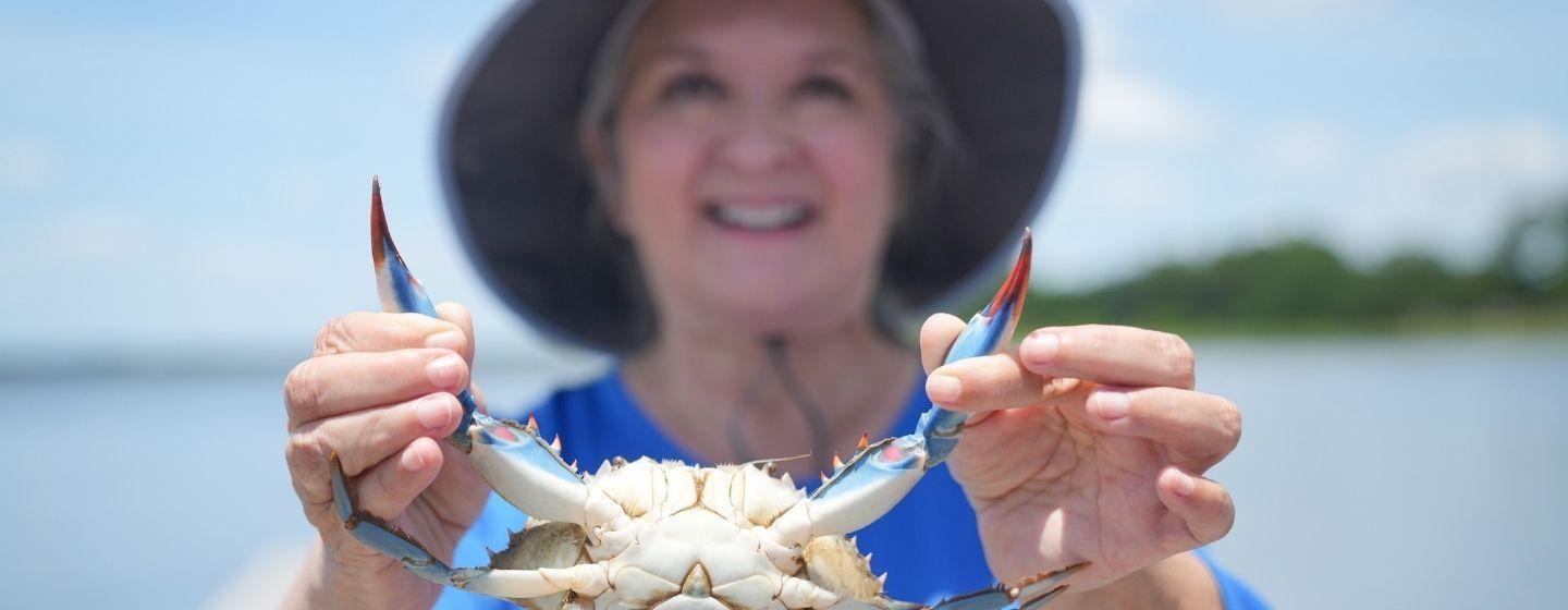Sheri Castle holding up a blue crab.