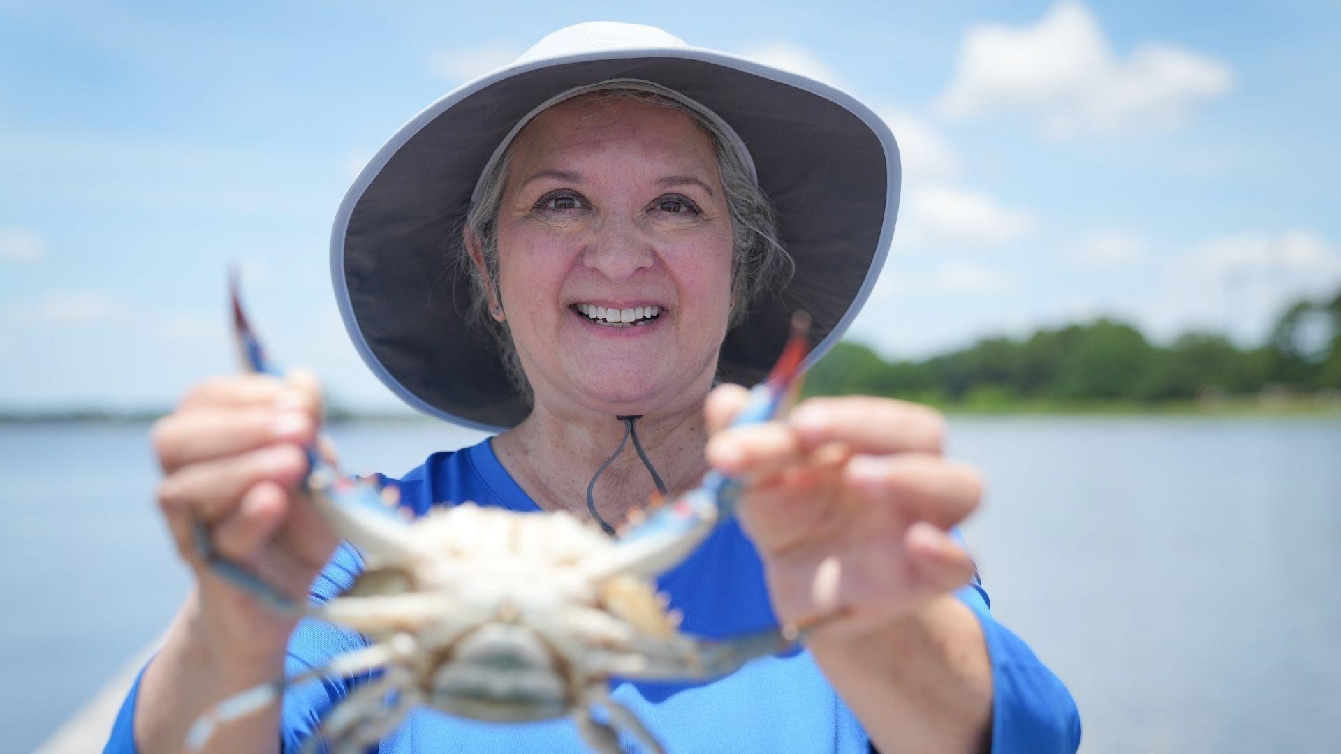 Sheri Castle holding up a blue crab.