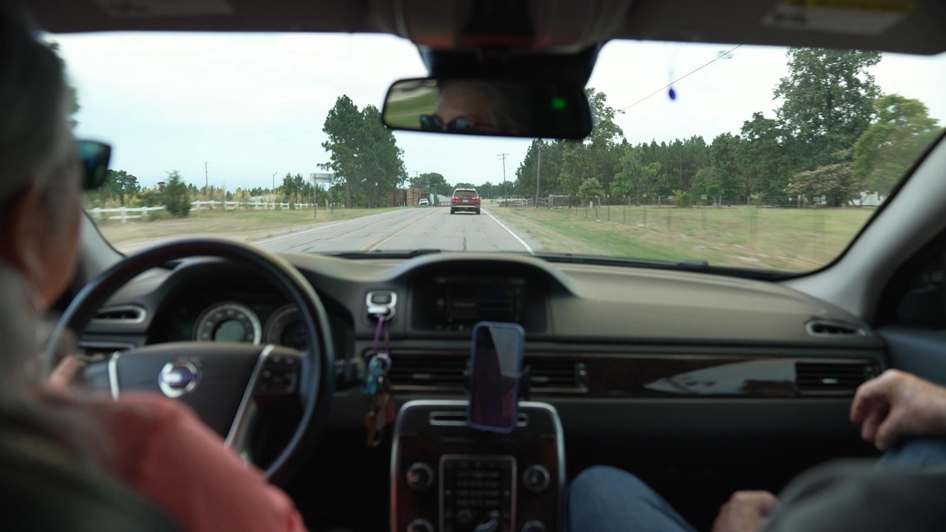 Sheri Castle driving while Bill Smith sits in the passenger seat.