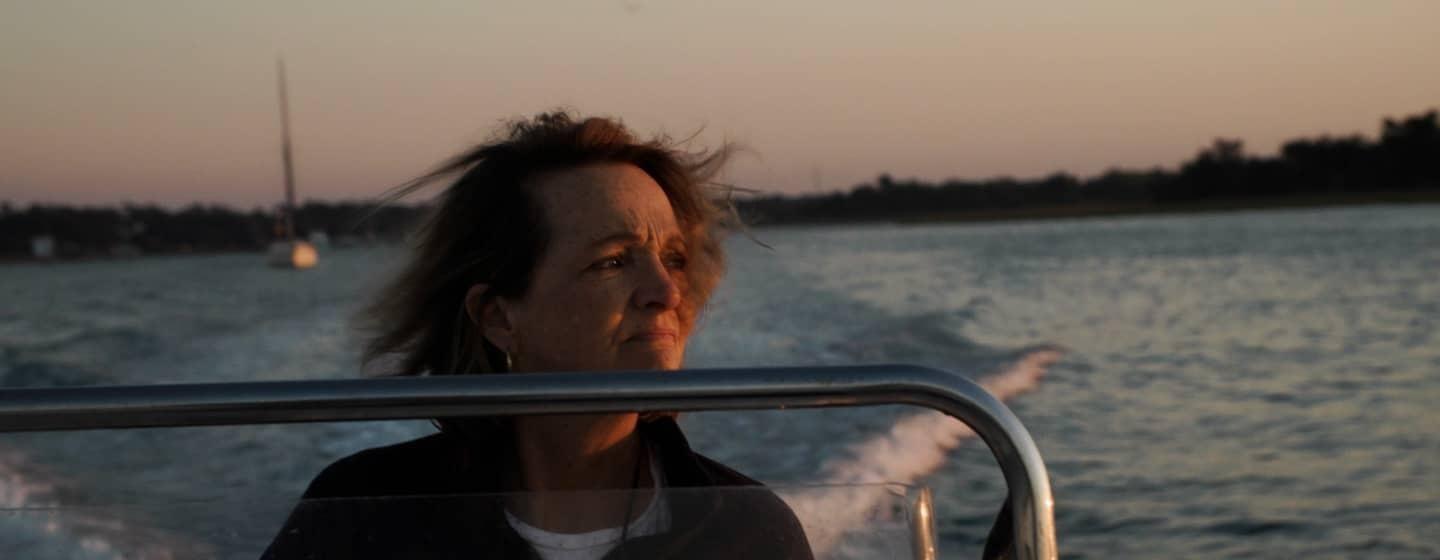 woman on boat at evening facing sunset