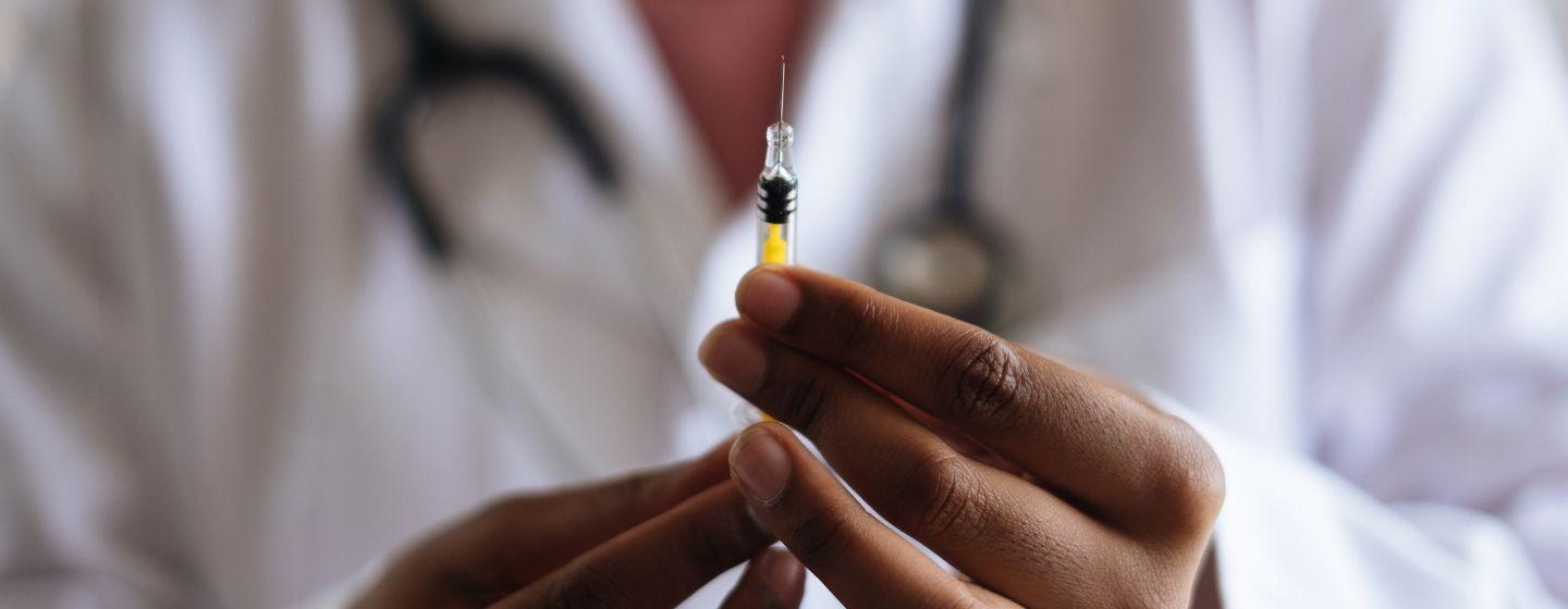A physician prepares a vaccine shot.