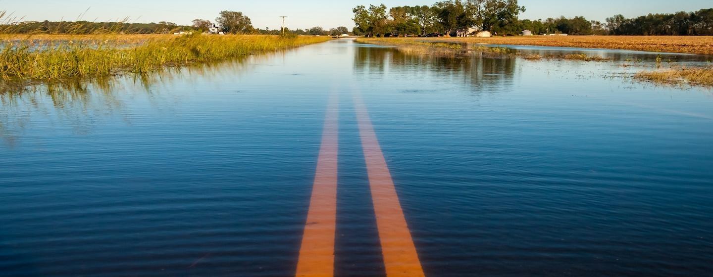 long country road, street flooded over covered in water for miles