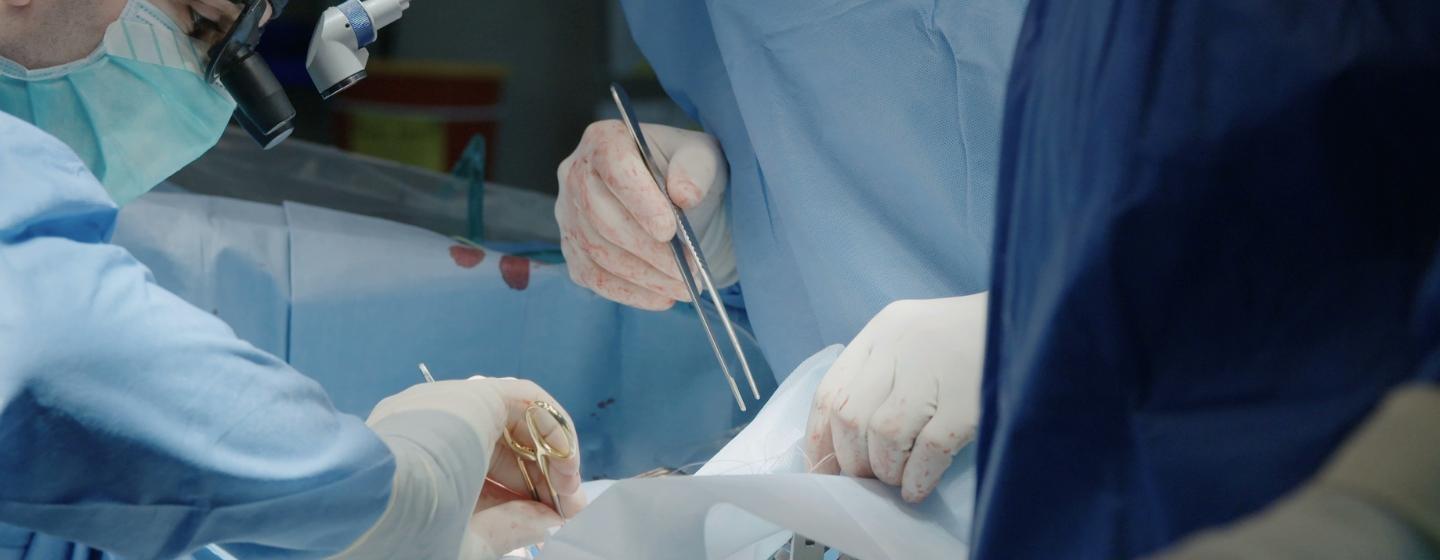 Two surgeons performing surgery on a patient.