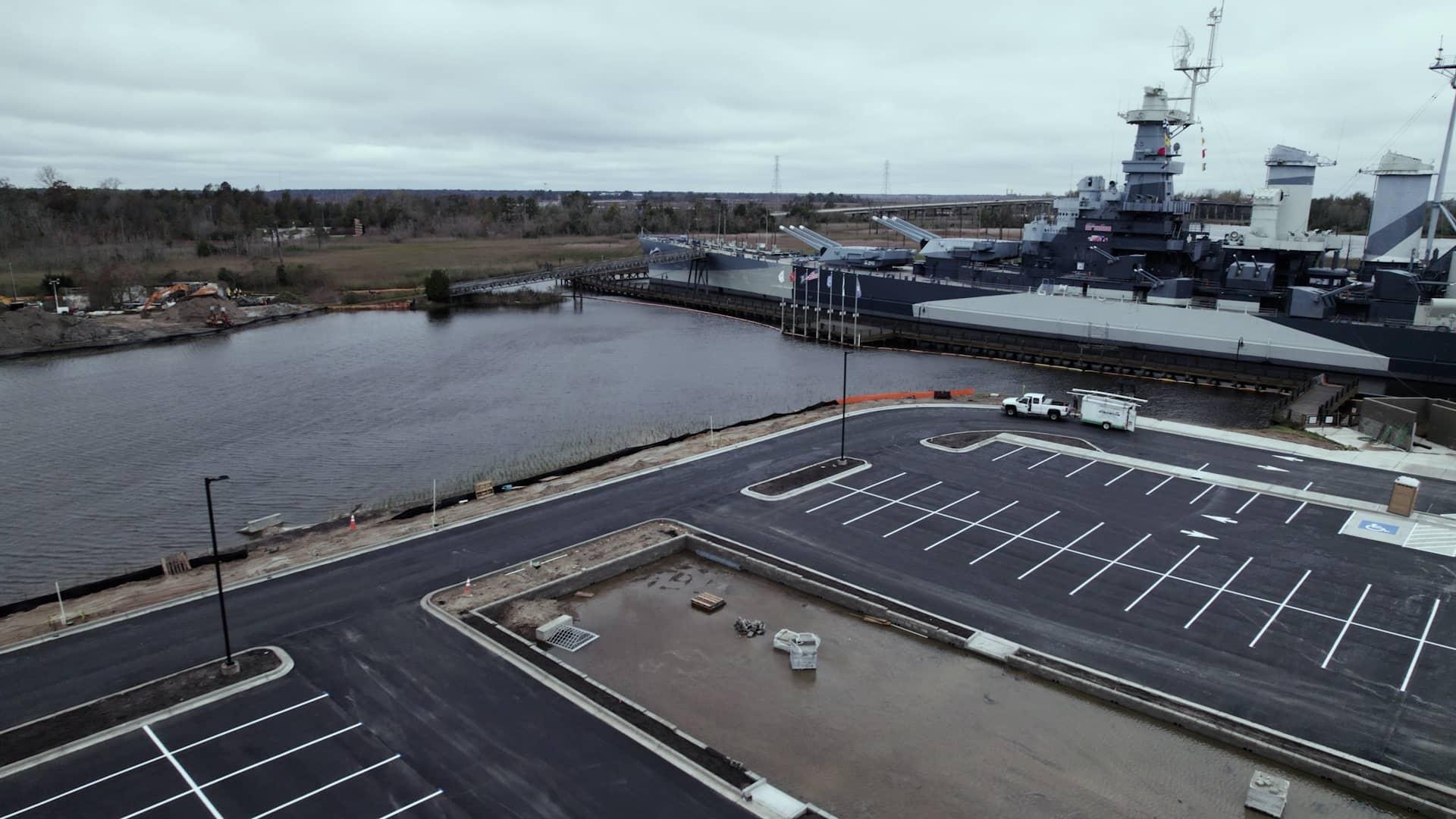 High tide when the tidal creek and wetland are completely submerged (upper part of image). Adjacent to the wetland, the newly elevated parking lot is dry, and the yet-to-be-planted bioswale contains water.