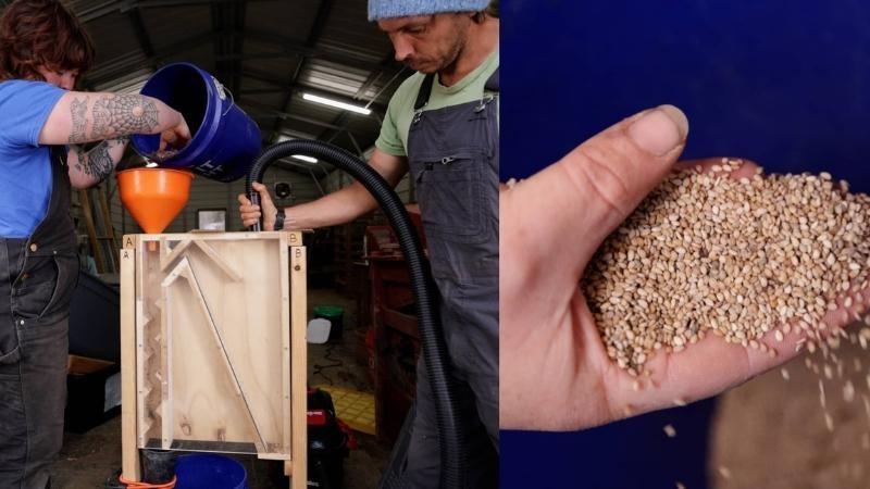 This is a composite image. The photo on the left shows two people in overalls and T-shirts standing with a rectangular wooden device in between them. The device has some internal structure with different compartments. At the top of the device, the woman on the left scoops something from a blue five-gallon bucket into a bright orange funnel so that it falls through the wooden device. The man on the right holds a black plastic hose to the other side of the device. The photograph on the right shows a hand full of sesame seeds against a dark blue background.