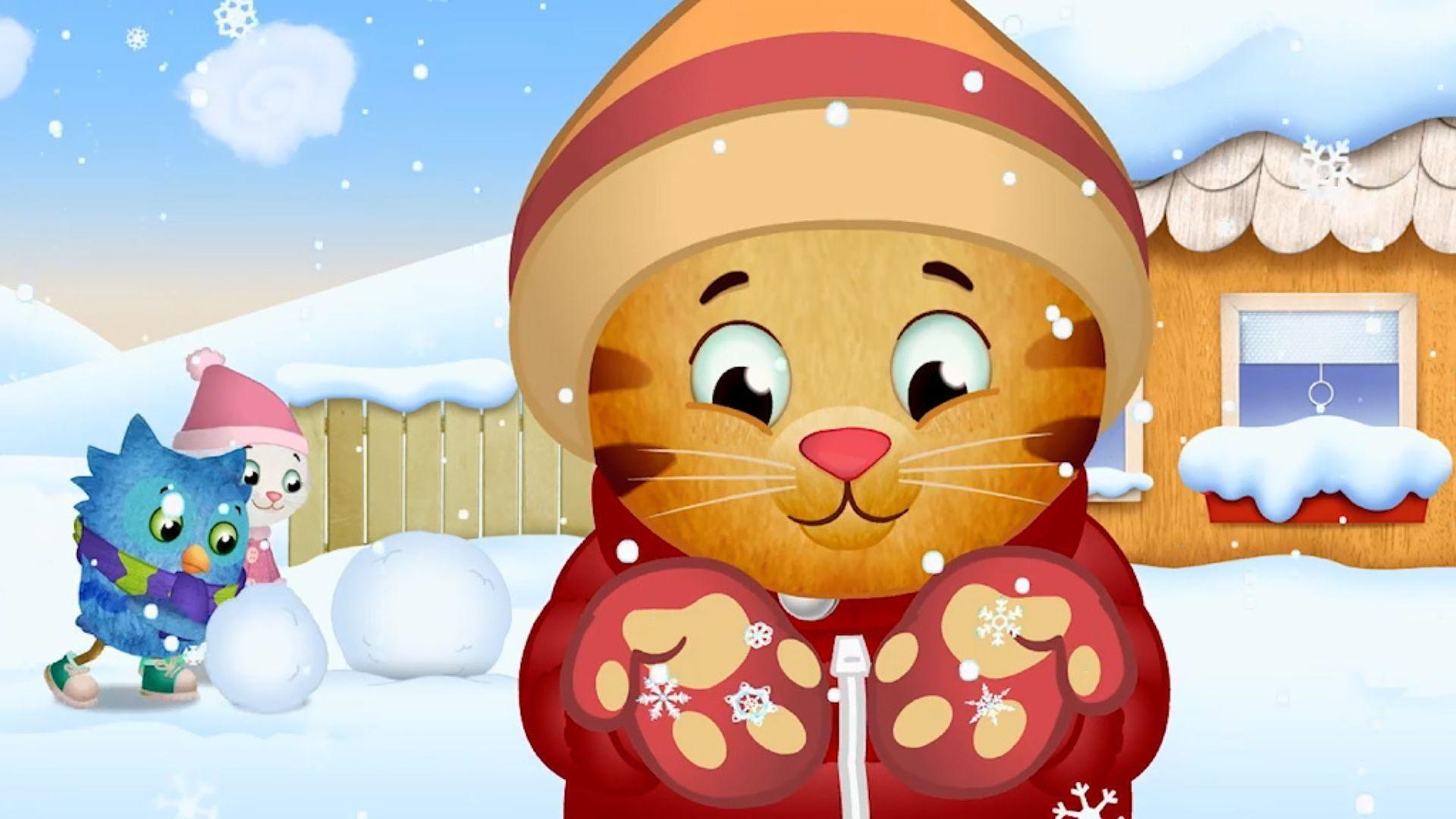 Daniel Tiger outside in the snow dressed in winter gear while catching snowflakes. O the Owl and Katarina Kittycat are behind him to the rolling balls of snow.
