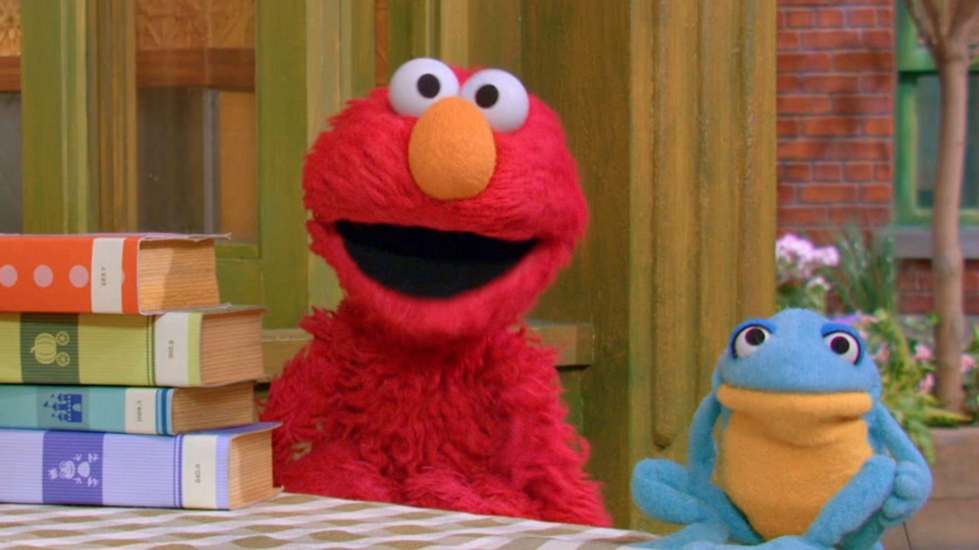 Elmo and a frog, as seen in Sesame Street.