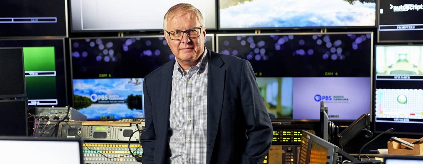 PBS North Carolina Chief Technology Officer, Fred Engel, standing in front of an array of screens.