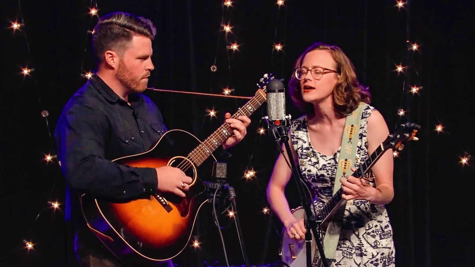 Couple performing acoustic guitar and singing