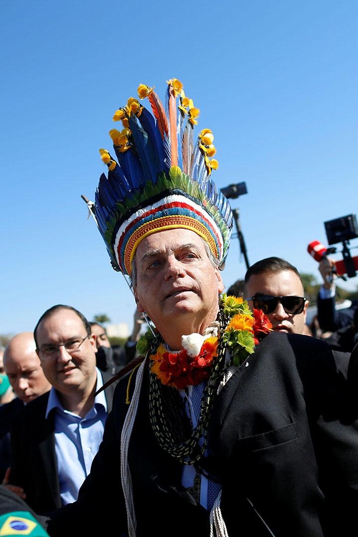 Brazil's President Jair Bolsonaro wears a headdress during a meeting with his indigenous supporters.
