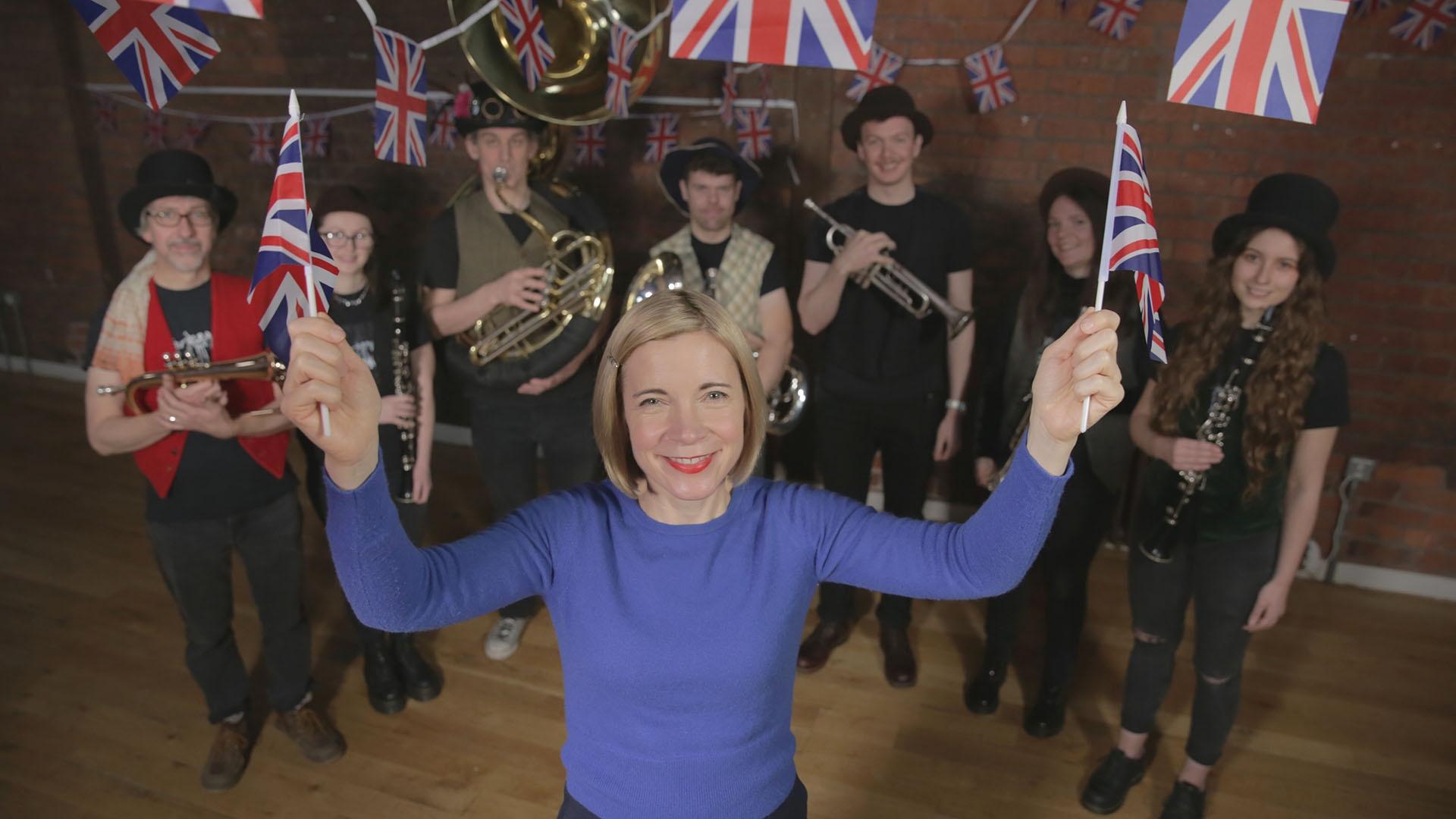 Lucy Worsley with British flags and a band.