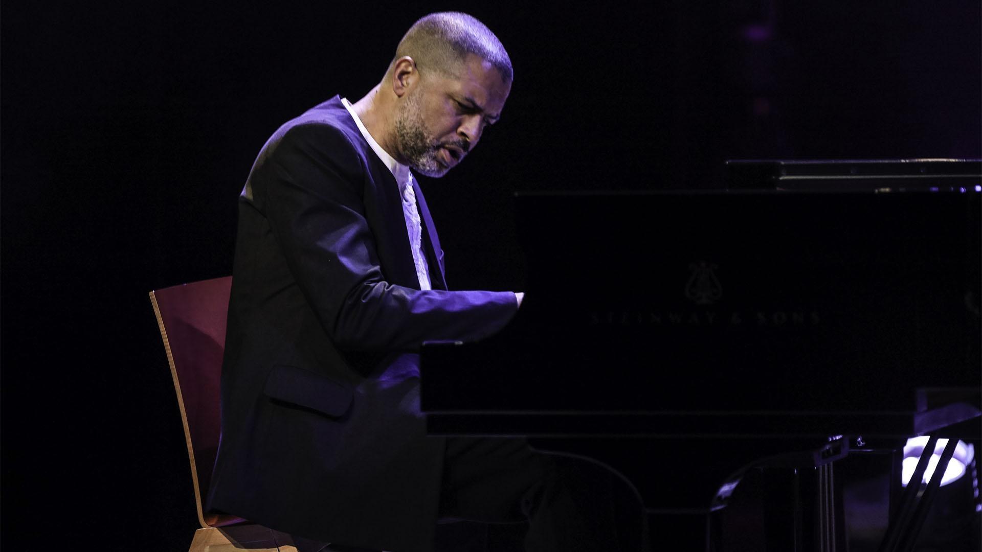 Portrait image of Jason Moran playing piano.