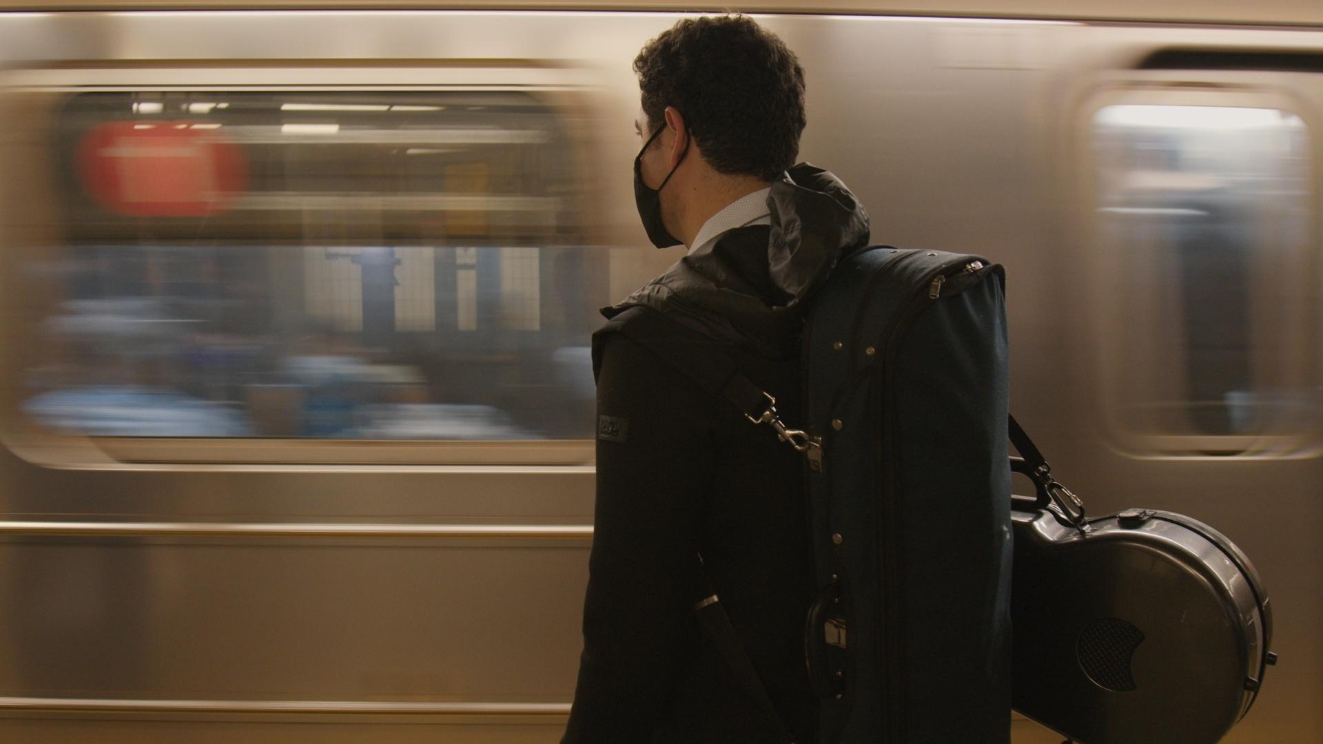 Chamber Music Society of Lincoln Center artist Arnaud Sussmann waits for a subway to arrive. 