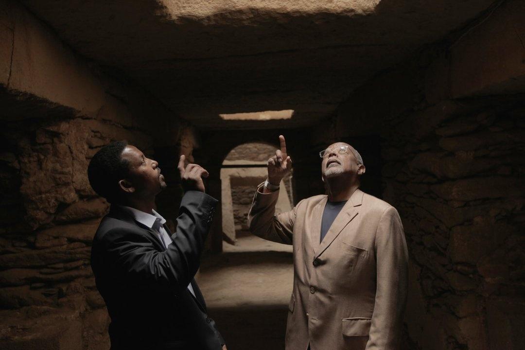 Henry Louis Gates, Jr. and Assistant Professor Abebaw Gela marvel from the tunnels below the stelae field in Axum, Ethiopia. Each stelae is made from a single piece of granite.