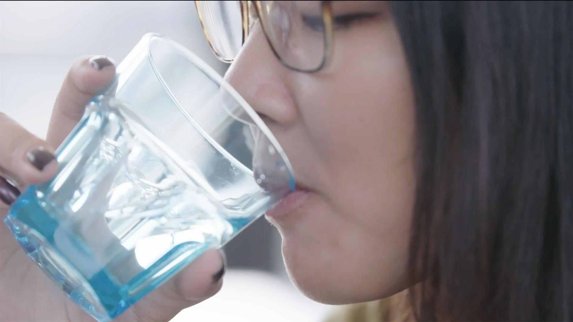 Woman drinking reclaimed water in Singapore.