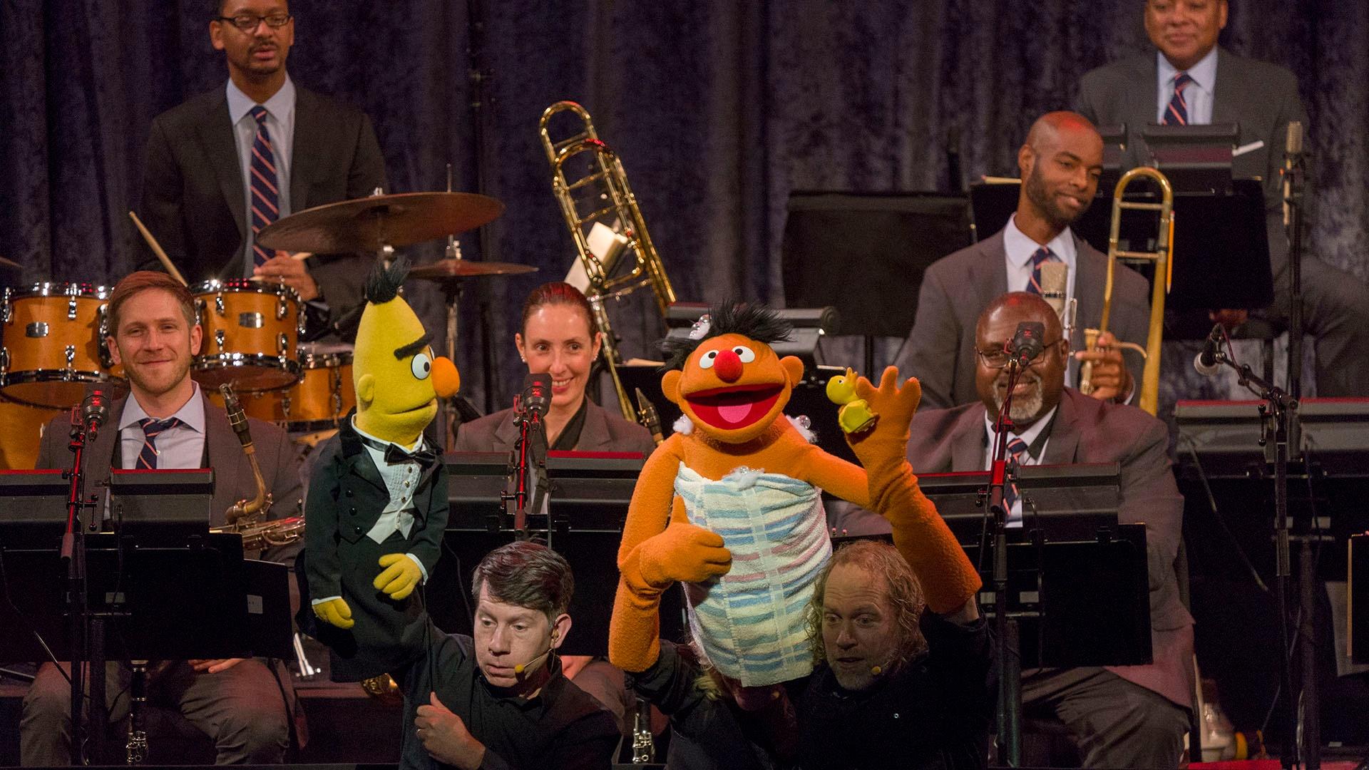 Image of Bert and Ernie on stage with the Jazz at Lincoln Center Orchestra.