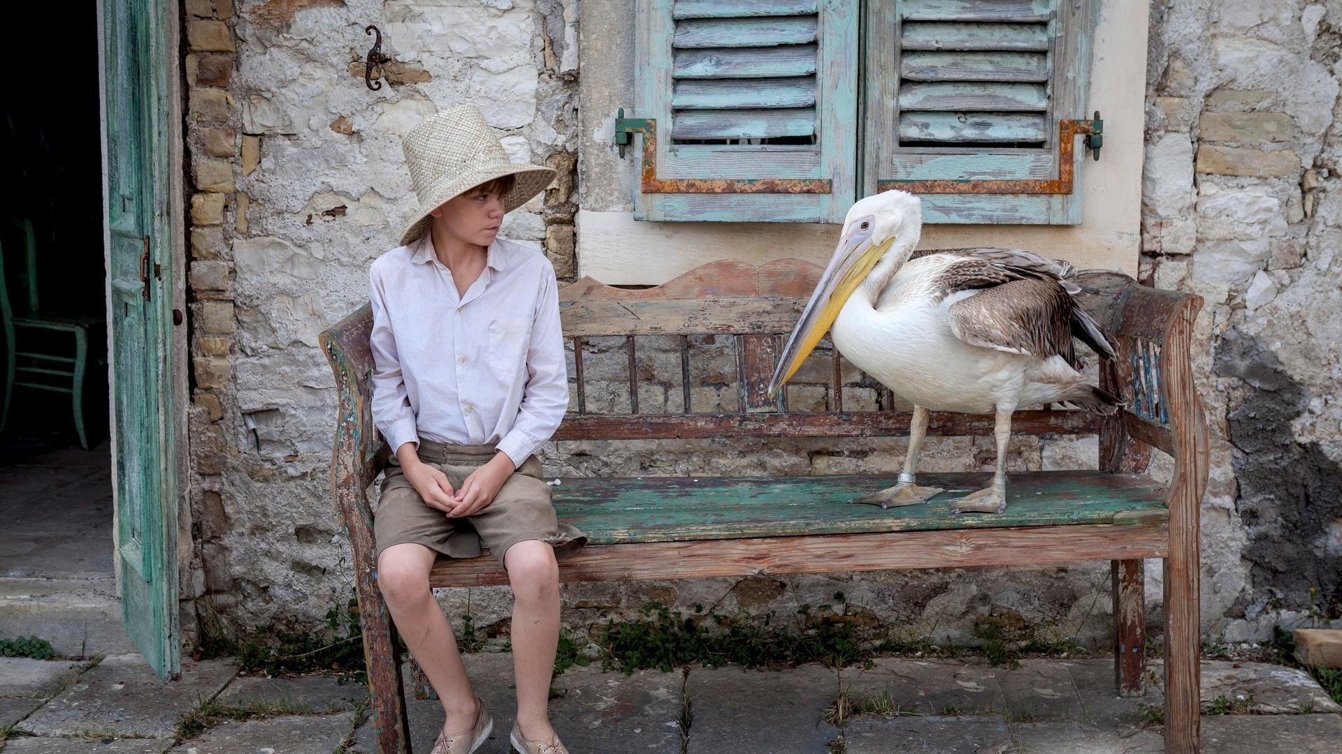 Gerry from “The Durrells in Corfu” sits next to a pelican.