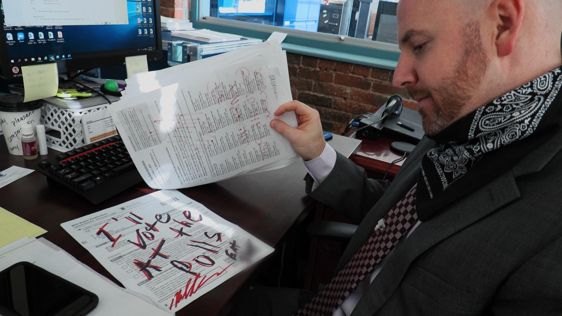 Rhode Island State Elections Director reads a hate message written on an application for a mail ballot.
